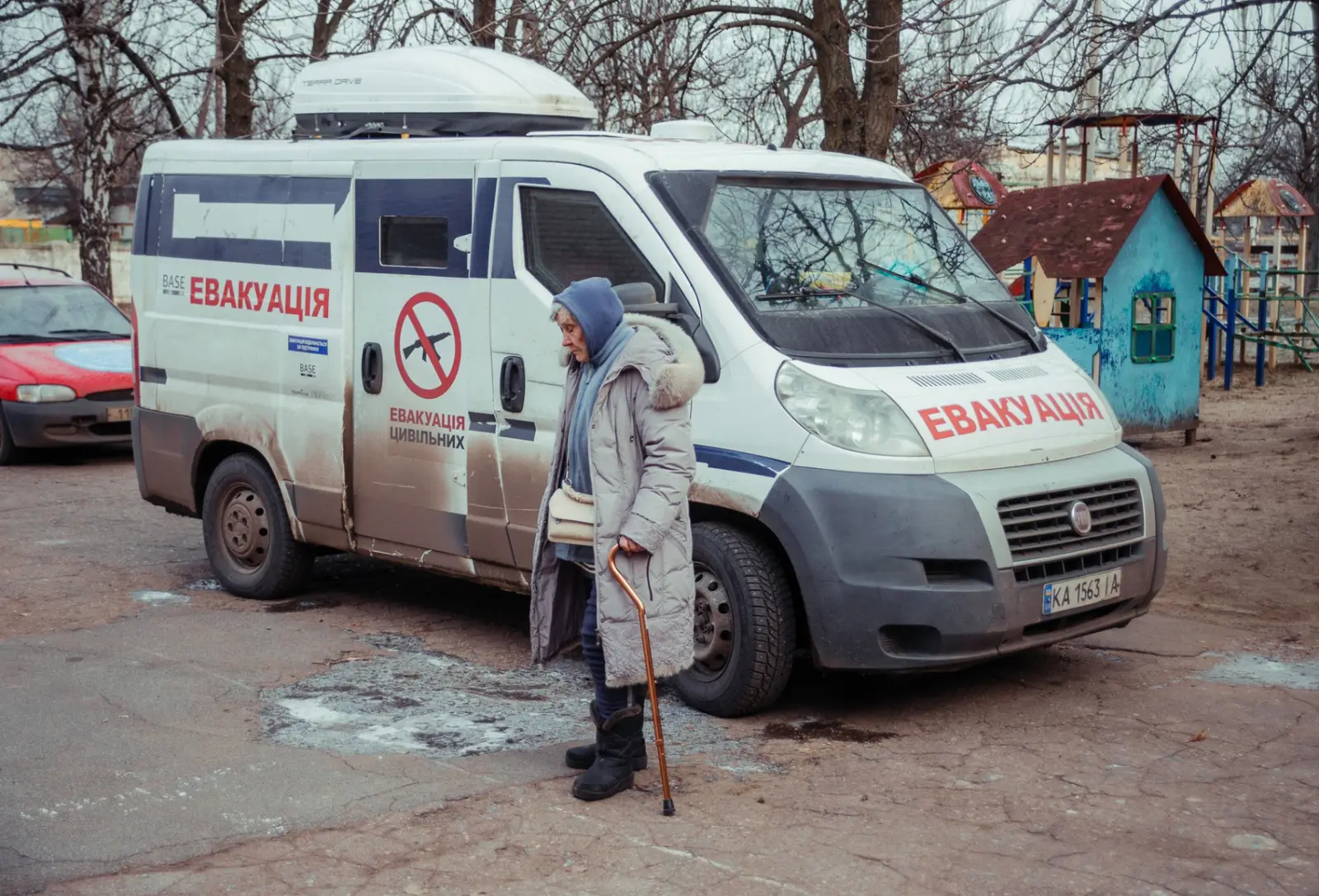 Older woman in front of an evacuation vehicle