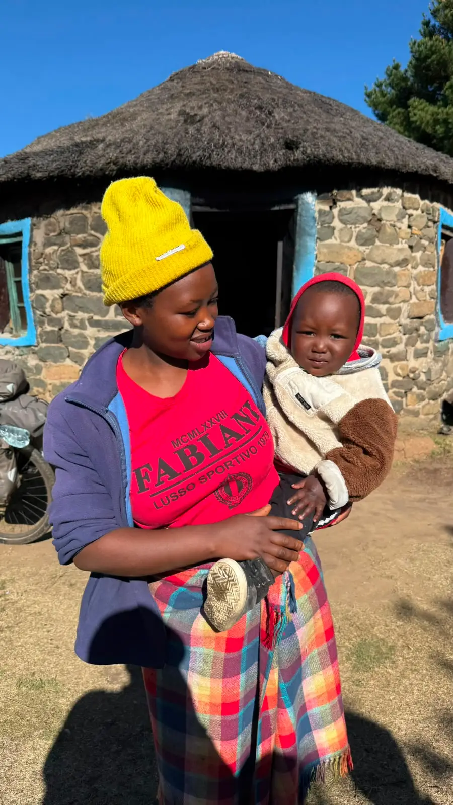 Mutter mit Kind vor ihrer Hütte in Lesotho