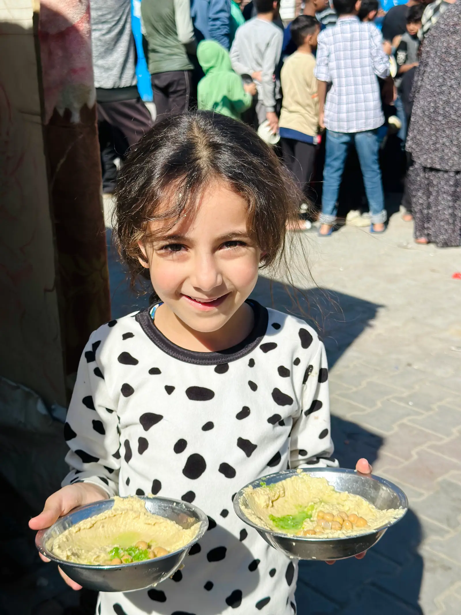 Girl with bowls of food in Gaza